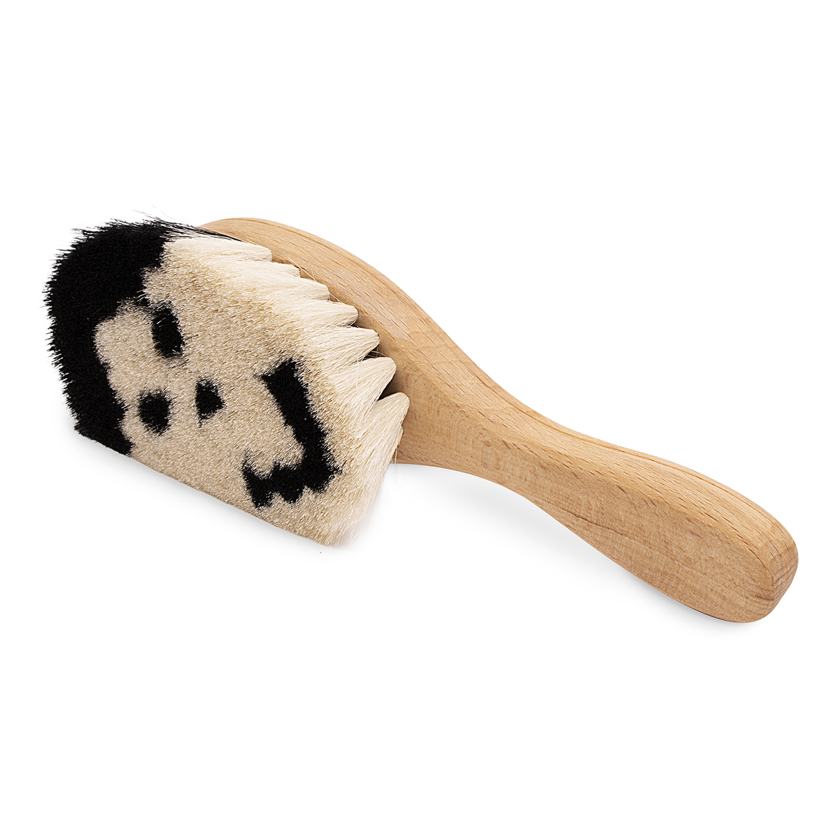 Holzbürste mit cremefarbenen und schwarzen Borsten, die in einem lächelnden Gesicht angeordnet sind.